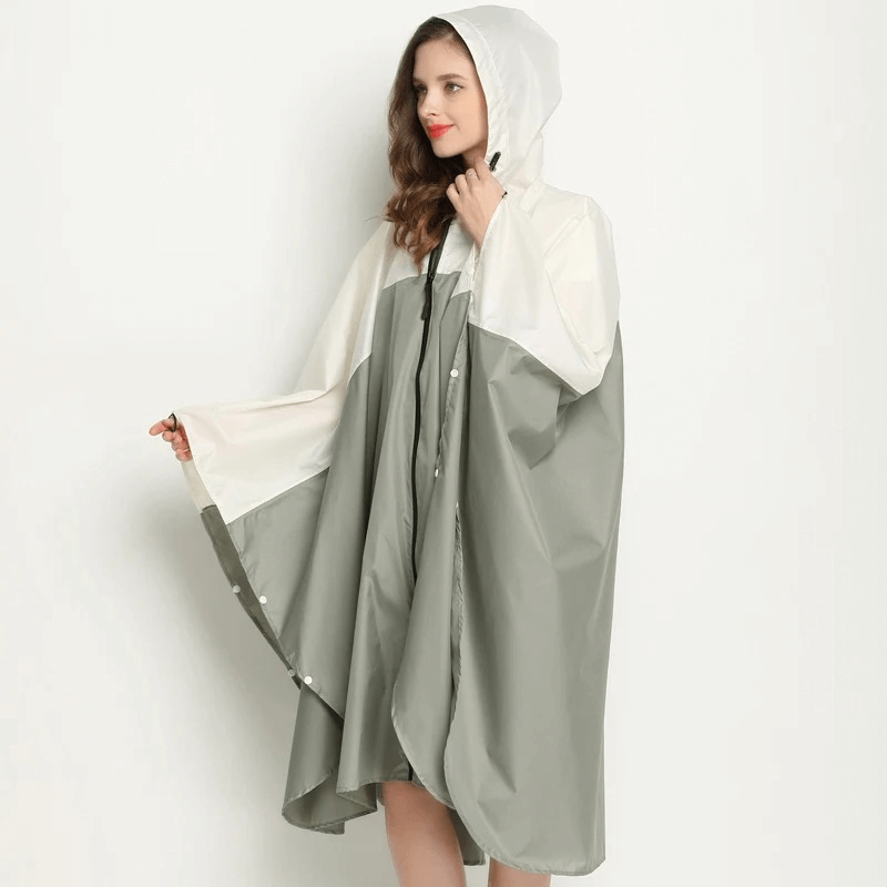 Women's waterproof raincoat-poncho in green and white with hood, zipper, and windproof polyester, ideal for rainy days.